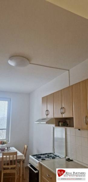 Prenájom 3 - izbový byt Bratislava - Petržalka - Kuchyňa v 3-izbovom byte, kuchynská linka, plynový sporák, jedálenský stôl pri okne.