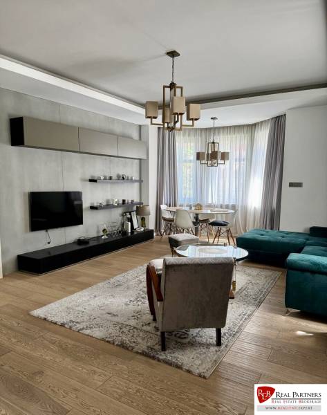 Prenájom veľkého luxusného 2izb bytu pri Bratislavskom hrade - Obývacia izba v 2-izbovom byte s podlahou s dreveným dekorom a štýlovým nábytkom.