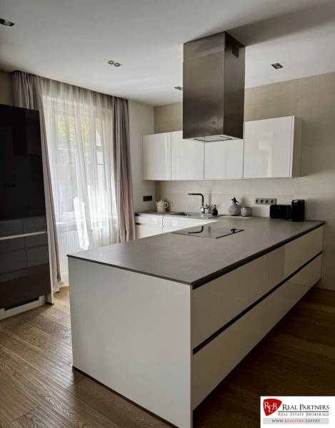 Prenájom veľkého luxusného 2izb bytu pri Bratislavskom hrade - Kuchyňa v 2-izbovom byte s ostrovom a podlahou s dreveným dekorom.