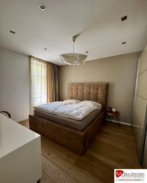 Prenájom veľkého luxusného 2izb bytu pri Bratislavskom hrade - Spálňa v 2-izbovom byte s posteľou a podlahou s dreveným dekorom.