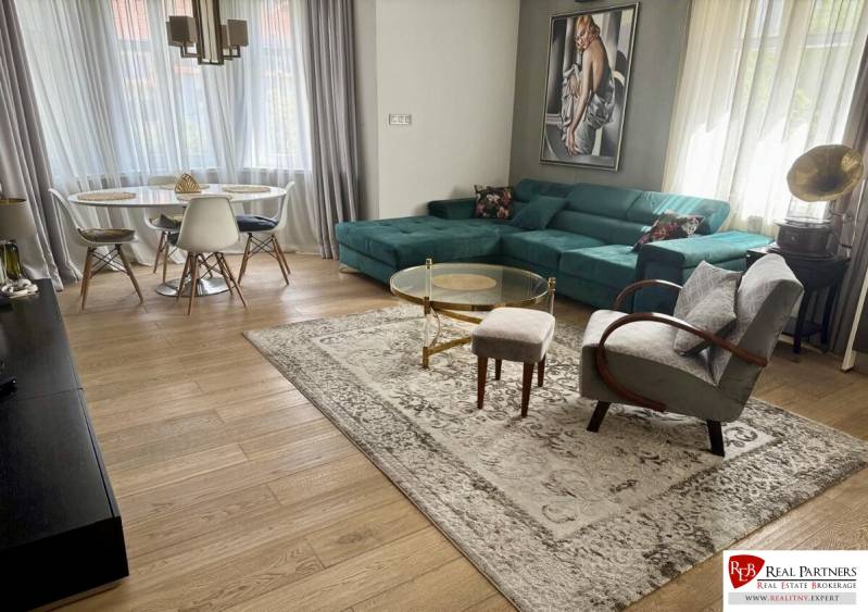 Prenájom veľkého luxusného 2izb bytu pri Bratislavskom hrade - Obývacia izba v 2-izbovom byte s podlahou s dreveným dekorom a elegantným nábytkom.