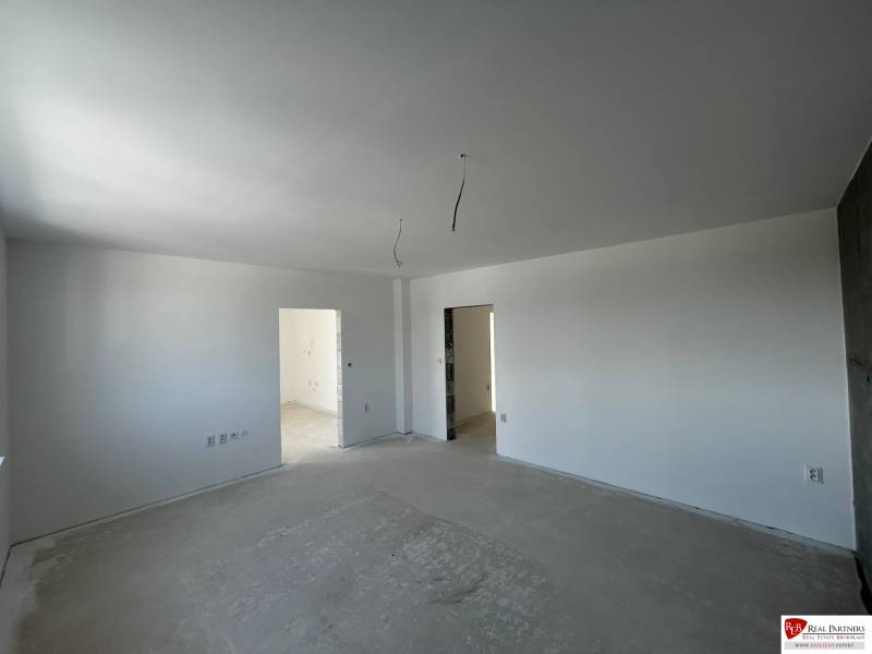 Predaj 3-izbového bytu len 15 minút od Bratislavy  - Svetlá priestranná miestnosť v 3-izbovom byte s holými stenami a prípravou na podlahu.