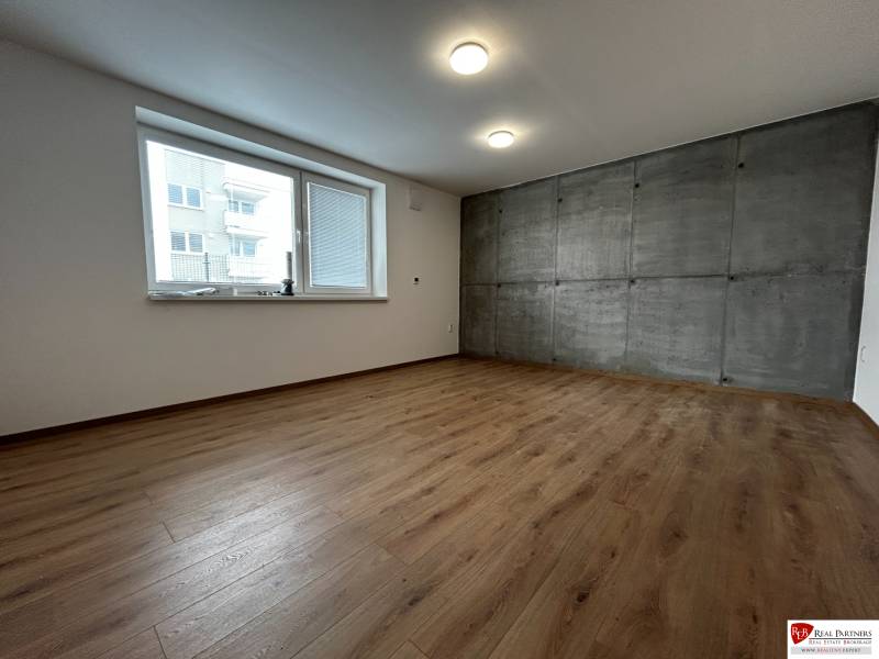 3-izbový byt v štandarde vrátane kuchyne len 15 minút od BA - Svetlá izba so sivou stenou a podlahou s dreveným dekorom v 4-izbovom byte.