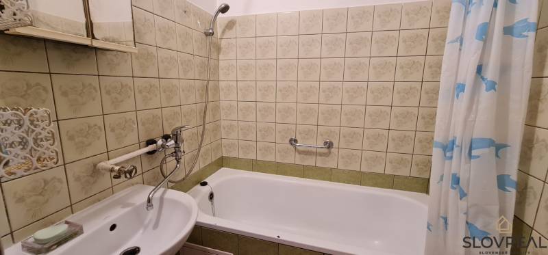 Na predaj 3i byt Levice, 61m2 - Kúpeľňa so zrkadlom a vaňou v 3-izbovom byte, obložená dekoratívnymi kachličkami.
