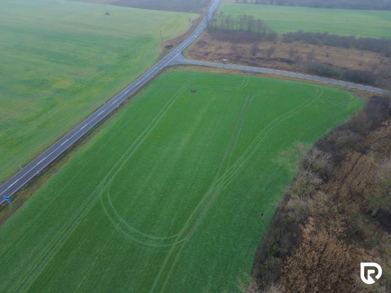 Znížená cena - Investičné pozemky  5722 m2 | Záhorská Ves - Záhorská Ves: Pozemky - komerčné pri cestnej križovatke, zelené pole a zeleň.