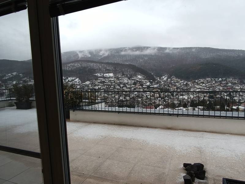 Štýlový 2-izbový byt s exkluzívnou terasou 102 m²  - Výhľad na zasneženú krajinu v Nová Baňa z balkóna bytu na ulici Pod sekvojou.