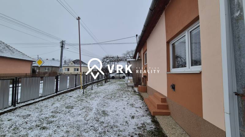 3 IZBOVÝ RODINNÝ DOM S GARÁŽOU, VEĽKÉ OZOROVCE - Rodinný dom na ulici Nová vo Veľkých Ozorovciach so zasneženým dvorom a plotom.