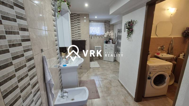 3 IZBOVÝ RODINNÝ DOM S GARÁŽOU, VEĽKÉ OZOROVCE - Kúpeľňa v rodinnom dome s kachličkovou stenou, bidetom, práčkou a dekoráciami.