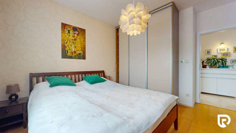 4i byt s atmosférou domu, terasou a parkovaním | Vrakuňa, 129m2 - Spálňa v 4-izbovom byte s obrazom na stene a podlahou s dreveným dekorom.