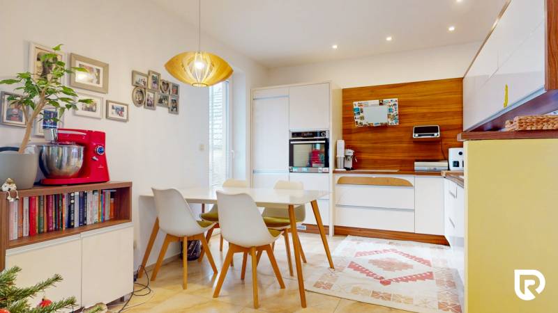 4i byt s atmosférou domu, terasou a parkovaním | Vrakuňa, 129m2 - Kuchyňa v 4-izbovom byte s jedálenským stolom, izbovými rastlinami a dreveným dekorom.