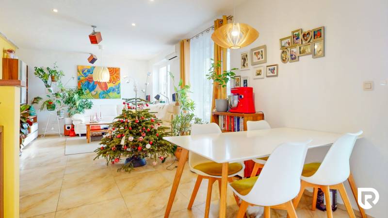 4i byt s atmosférou domu, terasou a parkovaním | Vrakuňa, 129m2 - Svetlá obývačka so sviatočnou výzdobou, jedálenským stolom a rastlinami v 4-izbovom byte.