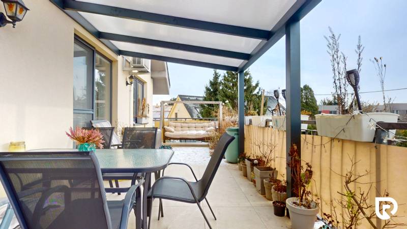 4i byt s atmosférou domu, terasou a parkovaním | Vrakuňa, 129m2 - Terasa so skleneným stolom a stoličkami v 4-izbovom byte.