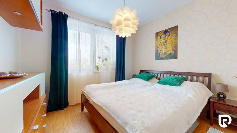 4i byt s atmosférou domu, terasou a parkovaním | Vrakuňa, 129m2 - Spálňa v 4-izbovom byte s veľkou posteľou, lustrom a podlahou s dreveným dekorom.