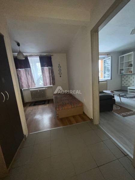 PREDAJ: 1i byt 32 m2; Bazovského; Zvolen-Sekier; 79.500 € - Interiér 1-izbového bytu s posteľou a podlahou s dreveným dekorom.