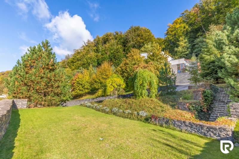 Nadštandardná 6-izbová vila v prominentnej lokalite - Záhrada vily na Karpatskej ulici v Marianke obklopená zeleňou a stromami.