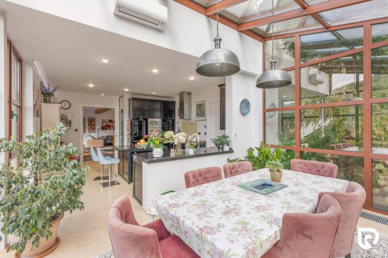 Nadštandardná 6-izbová vila v prominentnej lokalite - Kuchyňa s jedálenským stolom a rastlinami vo vile.