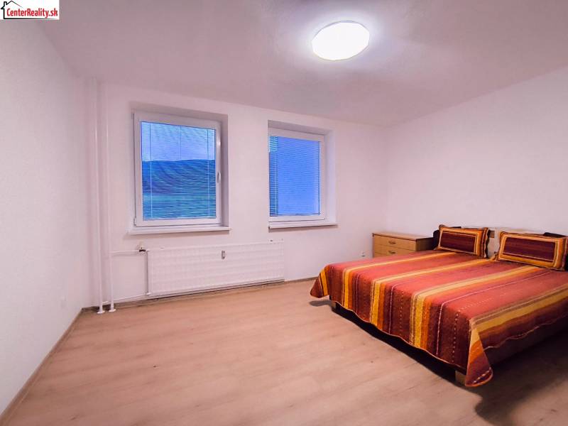 ‼️  PRENÁJOM  - 2 IZBOVÉHO BYTU, PARTIZÁNSKE SÍDLISKO ŠÍPOK ‼️ - Spálňa s farebnou posteľou a podlahou s dreveným dekorom v 2-izbovom byte.