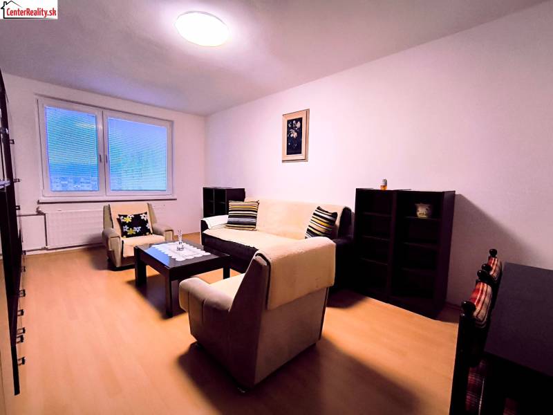 ‼️  PRENÁJOM  - 2 IZBOVÉHO BYTU, PARTIZÁNSKE SÍDLISKO ŠÍPOK ‼️ - Obývačka v 2-izbovom byte s minimalistickým nábytkom a podlahou s dreveným dekorom.