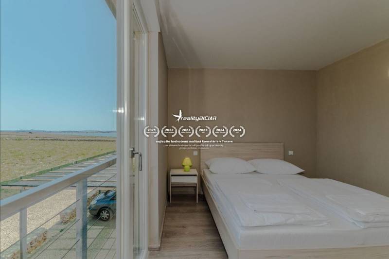 POVLJANA - dvojizbový apartmán D3 - 1. rad k moru - Spálňa v Rekreačnom apartmáne s výhľadom, posteľou a podlahou s dreveným dekorom.