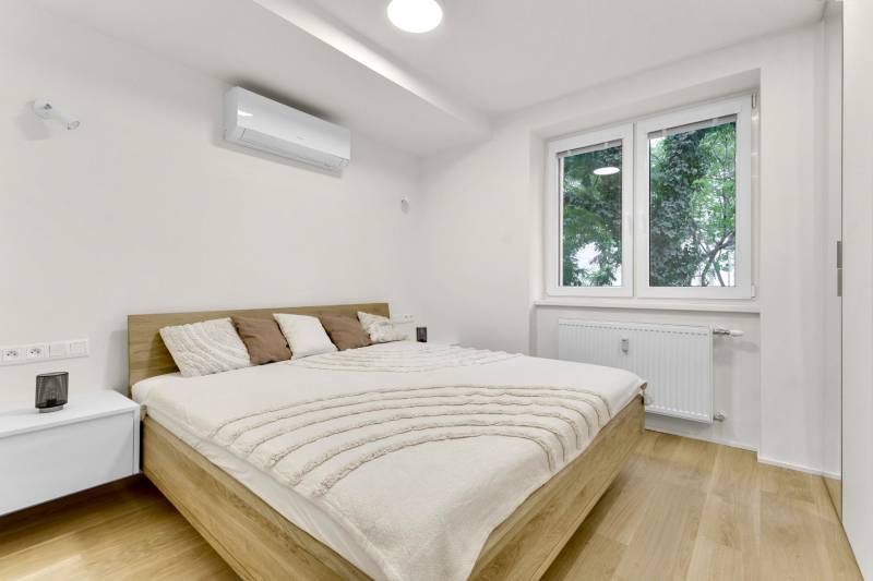 I Na predaj zrekonštruovaný 4i byt v Ružinove, Miletičova - Spálňa v 4-izbovom byte s dvojlôžkom, klimatizáciou a podlahou s dreveným dekorom.