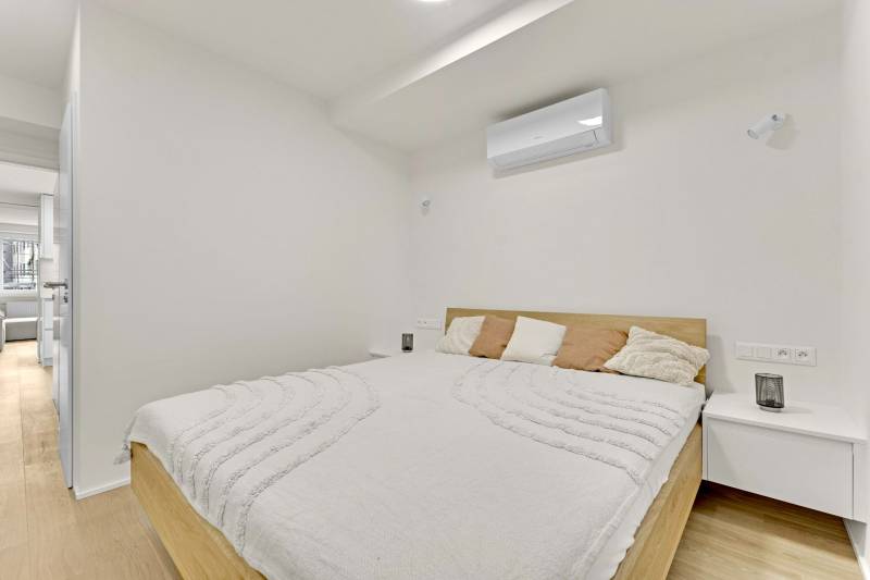 I Na predaj zrekonštruovaný 4i byt v Ružinove, Miletičova - Svetlá spálňa s klimatizáciou a posteľou vedľa nočného stolíka v 4-izbovom byte.