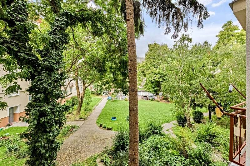I Na predaj zrekonštruovaný 4i byt v Ružinove, Miletičova - Zeleň a strom v záhrade, výhľad z 4-izbového bytu v Bratislave, Ružinove na Miletičovej.
