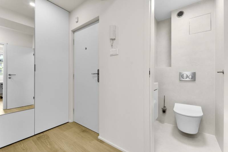 I Na predaj zrekonštruovaný 4i byt v Ružinove, Miletičova - Vstupná hala a toaleta v 4-izbovom byte s podlahou s dreveným dekorom.