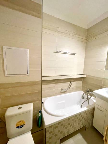 Predáj 1i čiastočne zrekonštruovaný byt s loggiou - Kúpeľňa v 1-izbovom byte s vaňou, umývadlom a toaletou, svetlé obklady.