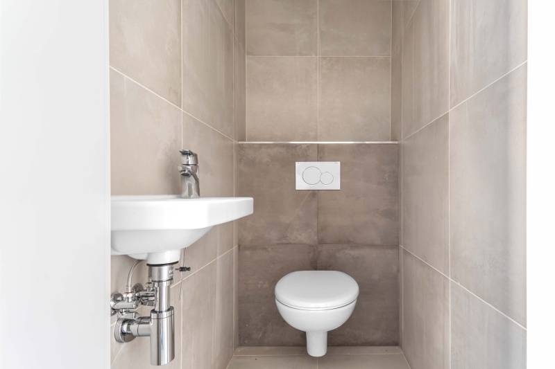 I PREDAJ novostavba 4i rodinného domu s terasou a záhradkou - Toaleta so stenami obloženými kachličkami v rodinnom dome.