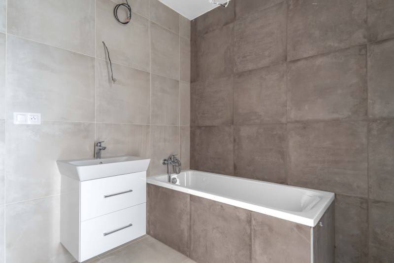 I PREDAJ novostavba 4i rodinného domu s terasou a záhradkou - Kúpeľňa s vaňou a umývadlom v rodinnom dome, steny s béžovým obkladom.