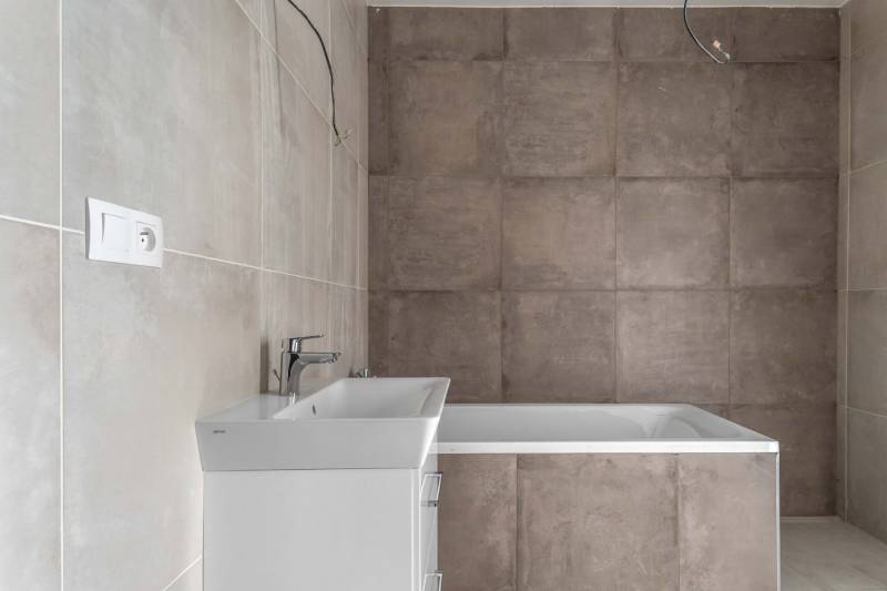 I PREDAJ novostavba 4i rodinného domu s terasou a záhradkou - Kúpeľňa s vaňou a umývadlom v rodinnom dome, obložená veľkoformátovými dlaždicami.