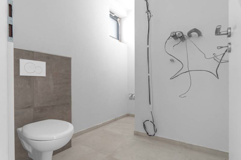 I PREDAJ novostavba 4i rodinného domu s terasou a záhradkou - Kúpeľňa v rodinnom dome s toaletou a nedokončenými rozvodmi na stene.