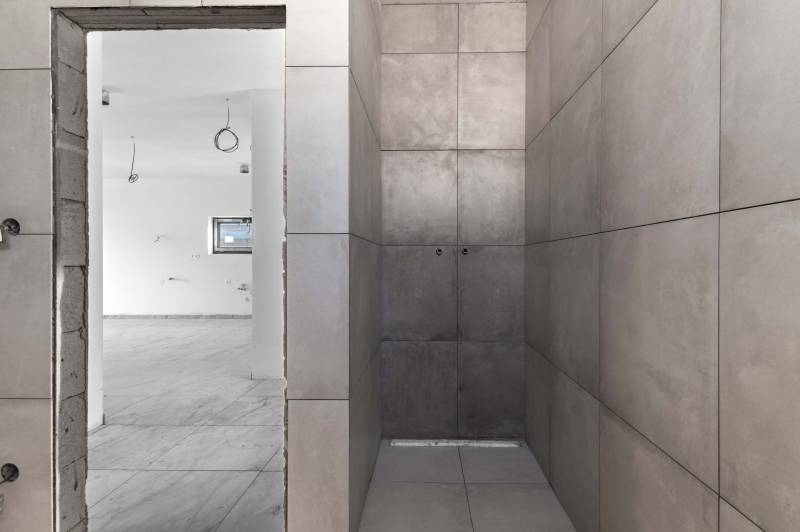 I NA PREDAJ 4i rodinný dom s veľkým pozemkom v Galante - Prázdny interiér rodinného domu so svetlými stenami a dlažbou.