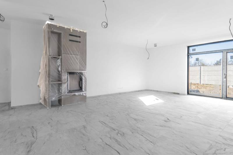 I NA PREDAJ 4i rodinný dom s veľkým pozemkom v Galante - Interiér rodinného domu s krbom a veľkými presklenými dverami.