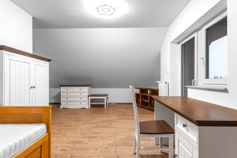 I Predaj štýlového tehlového domu v Rajke pri Bratislave - Izba s podlahou s dreveným dekorom, pracovným stolom a skriňou v rodinnom dome.