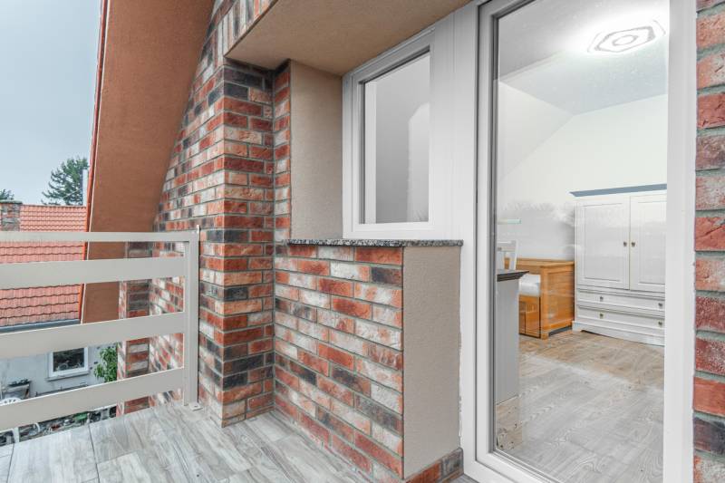 I Predaj štýlového tehlového domu v Rajke pri Bratislave - Balkón rodinného domu na ulici Jókai Mór v Rajke s tehlovým obkladom.