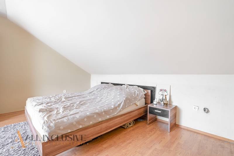 NA PREDAJ RODINNÉ DOMY S GARÁŽOU, DUNAJSKÁ STREDA - Spálňa v rodinnom dome s posteľou, nočným stolíkom a svietidlom pod šikmým stropom.