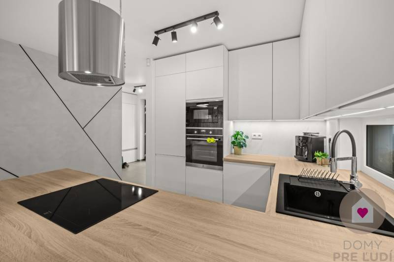 ROVINKA-Prenájom modernej, zariadenej novostavby 4 izbového rod.domu - Kuchyňa v 4-izbovom byte, s podlahou s dreveným dekorom a moderným kuchynským vybavením.