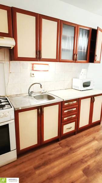 3 izbový byt pri električkovej trati s výhľadom na Draždiak - Kuchyňa v 3-izbovom byte s podlahou s dreveným dekorom a kuchynskou linkou.