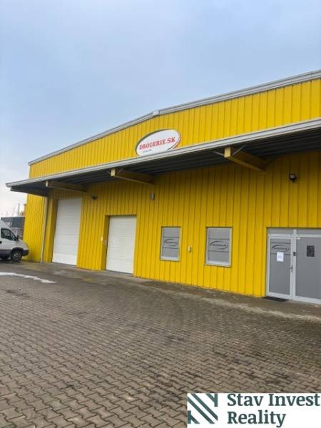  Prenájom skladu v Senci - paletové skladovanie  - Žltá budova skladu a haly na Poľnej ceste v Senci so vstupnými bránami.