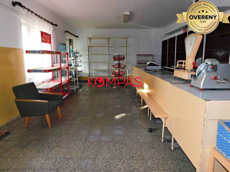 INVESTIČNÁ PRÍLEŽITOSŤ, BUDOVA NA PODNIKATEĽSKÉ ÚČELY - KALINKA - Interiér obchodných priestorov s pultom, regálmi a kreslom.