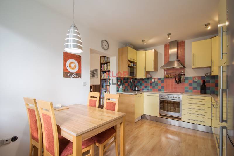 Pozrite si PRÍJEMNÝ 2i byt so ZARIADENÍM, LODŽIOU a KLIMATIZÁCIOU - Kuchyňa v 2-izbovom byte s jedálenským stolom, podlaha s dreveným dekorom.