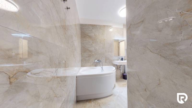 | Exkluzívny 4-izbový byt s obrovskou terasou | Stupava - Kúpeľňa v 4-izbovom byte s vaňou a svetlými obkladmi.