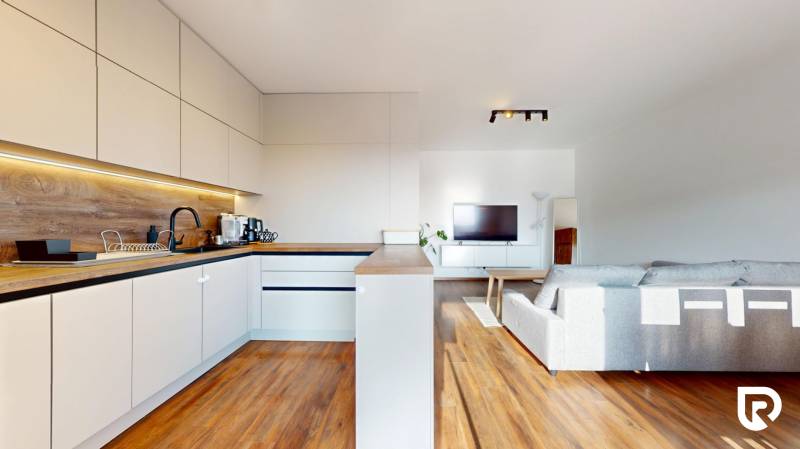 | Exkluzívny 4-izbový byt s obrovskou terasou | Stupava - Kuchyňa v 4-izbovom byte s pracovnou doskou a podlahou s dreveným dekorom.