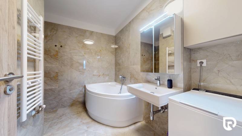 | Exkluzívny 4-izbový byt s obrovskou terasou | Stupava - Kúpeľňa s vaňou v 4-izbovom byte, kamenné obklady a biela sanita.