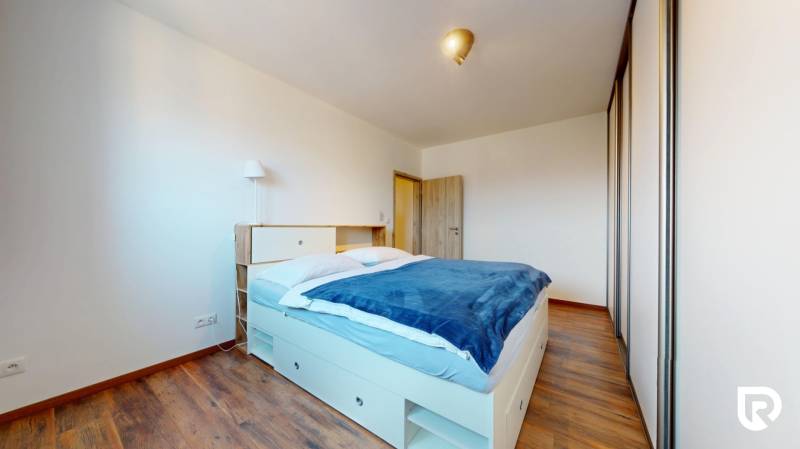 | Exkluzívny 4-izbový byt s obrovskou terasou | Stupava - Spálňa s manželskou posteľou, vstavanou skriňou, podlahou s dreveným dekorom v 4-izbovom byte.