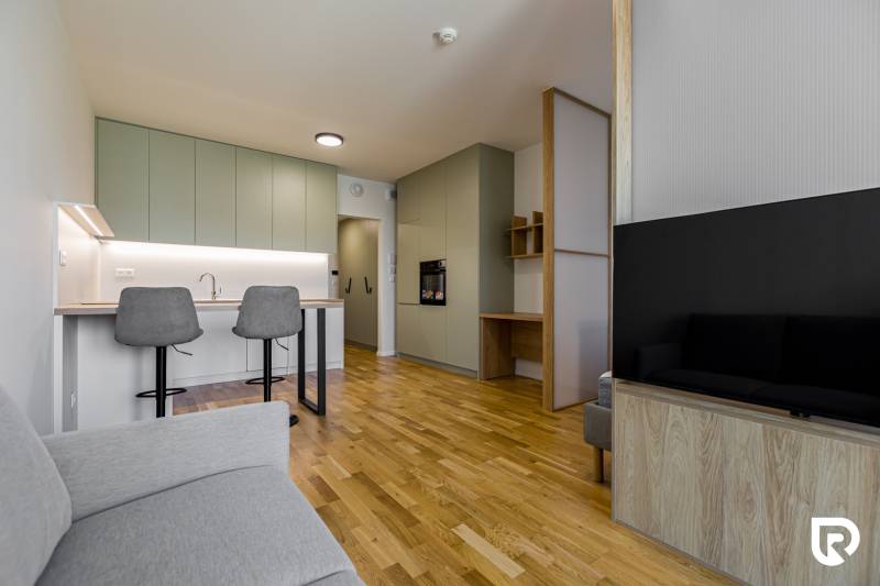 REZERVOVANÉ I METROPOLIS I Luxusný 1i byt I Staré Mesto - Obývačka v 1-izbovom byte s kuchynským kútom a podlahou s dreveným dekorom.