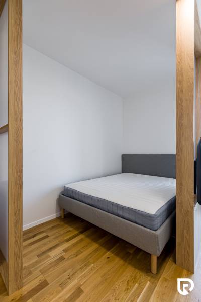 REZERVOVANÉ I METROPOLIS I Luxusný 1i byt I Staré Mesto - Manželská posteľ v 1-izbovom byte, podlaha s dreveným dekorom, svetlé steny.