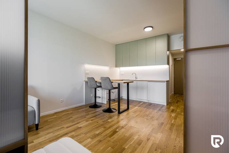 REZERVOVANÉ I METROPOLIS I Luxusný 1i byt I Staré Mesto - Kuchyňa v 1-izbovom byte s podlahou s dreveným dekorom a barovým pultom.