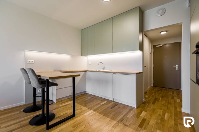 REZERVOVANÉ I METROPOLIS I Luxusný 1i byt I Staré Mesto - Kuchyňa v 1-izbovom byte s podlahou s dreveným dekorom a svetlým nábytkom.